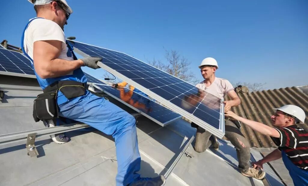 Técnicos instalando paneles fotovoltaicos para autoconsumo solar empresarial